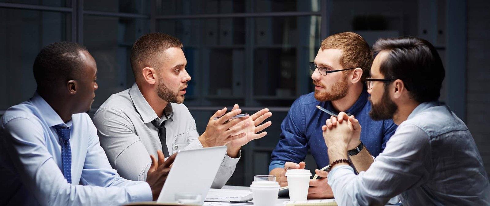 Young managers listening to colleague in office late in the evening